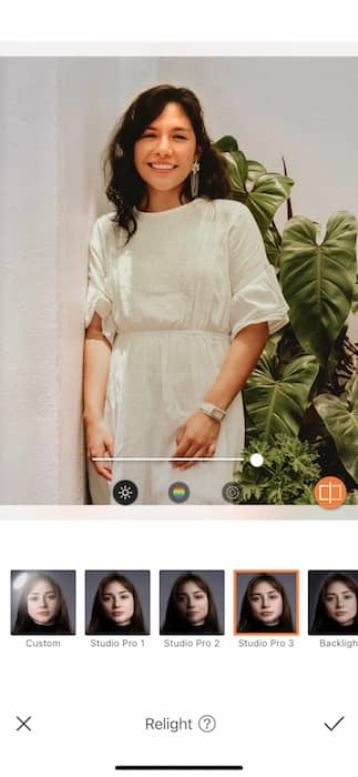  woman in a white dress standing in front of a green plant