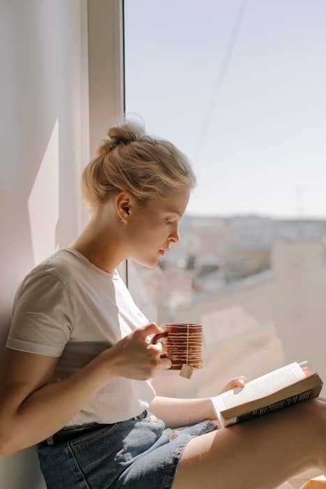 Picture of a white woman with pink hair drinking tea