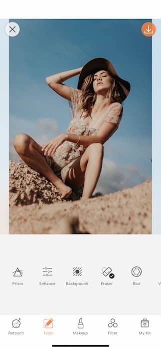 woman wearing a hat and floral dress sitting in the desert