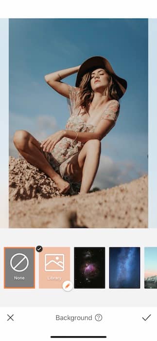 woman wearing a hat and floral dress sitting in the desert