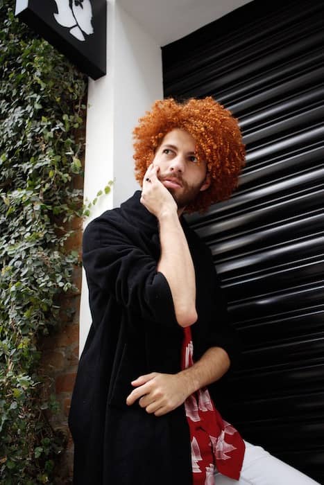 man with curly red hair in black blazer