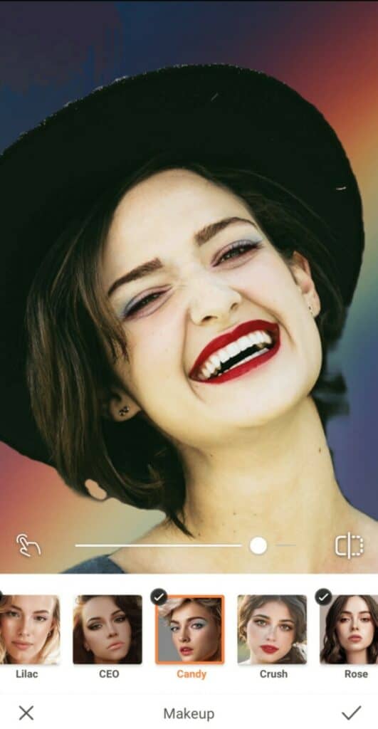 closeup of a laughing woman with red lipstick wearing a black hat