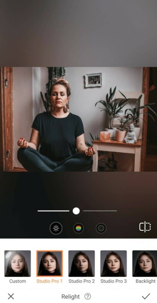 woman sitting and meditating next to plants