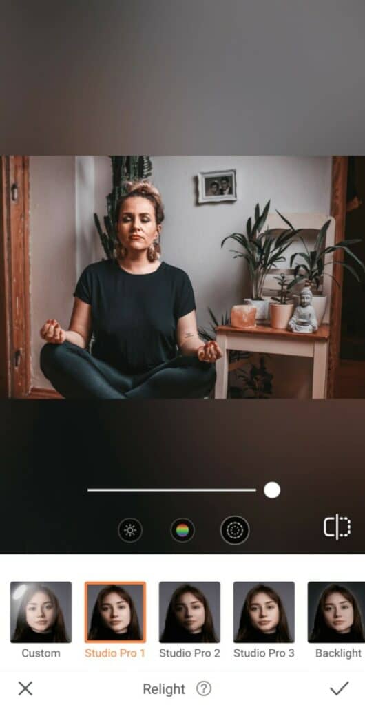 woman sitting and meditating next to plants