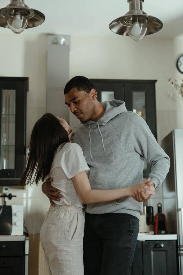 Casal abraçado dançando em uma cozinha