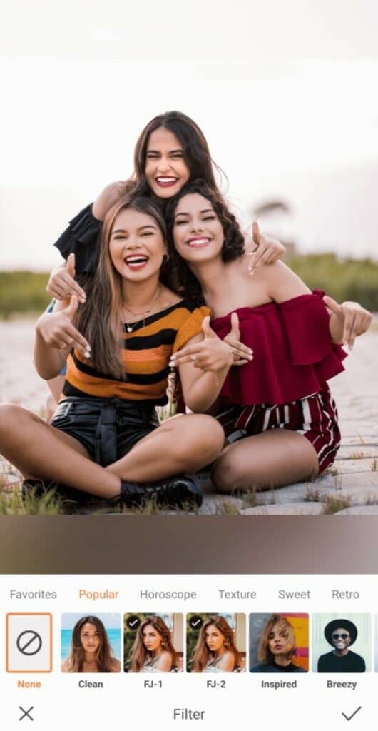 three smiling women taking a photo on the beach