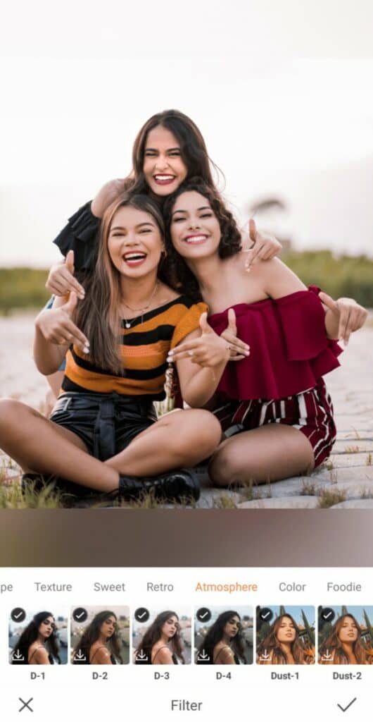 three smiling women taking a photo on the beach