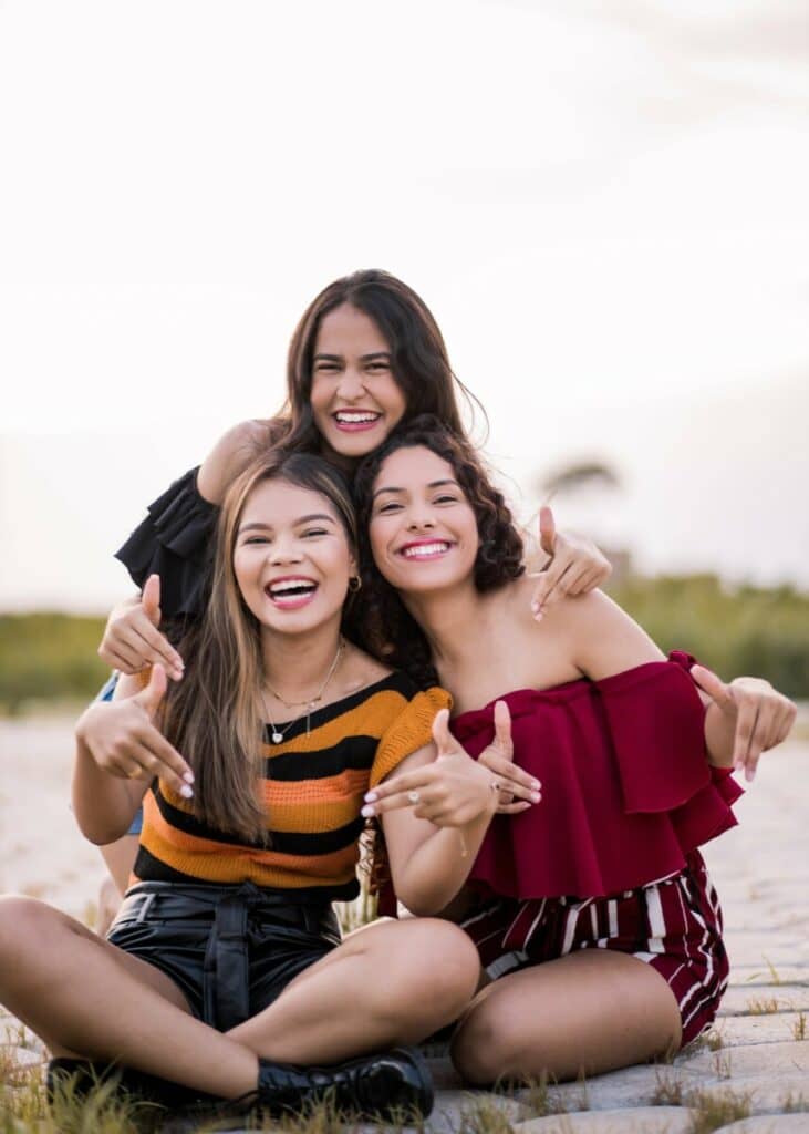 three smiling women taking a photo on the beach