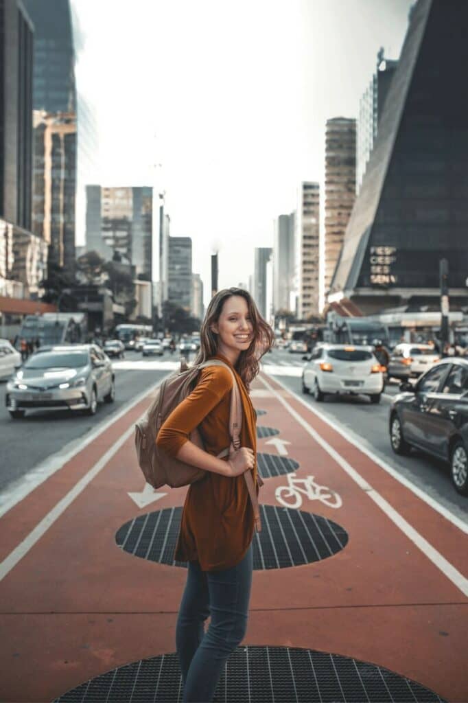 woman standing in the middle of a busy city street