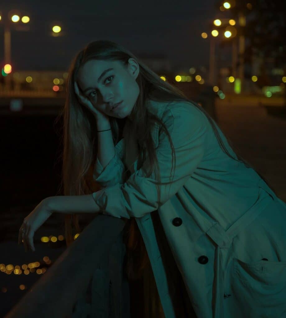 woman standing on a bridge at night