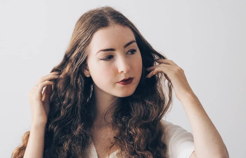 woman holding her long brown hair