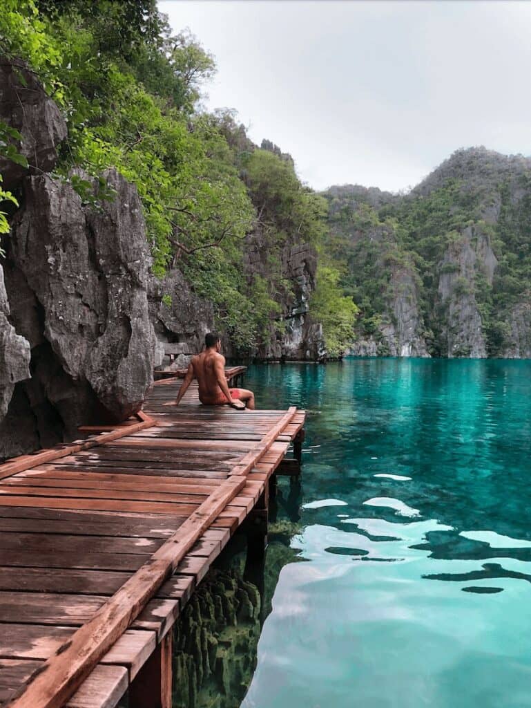 man sitting on a wooden jetty