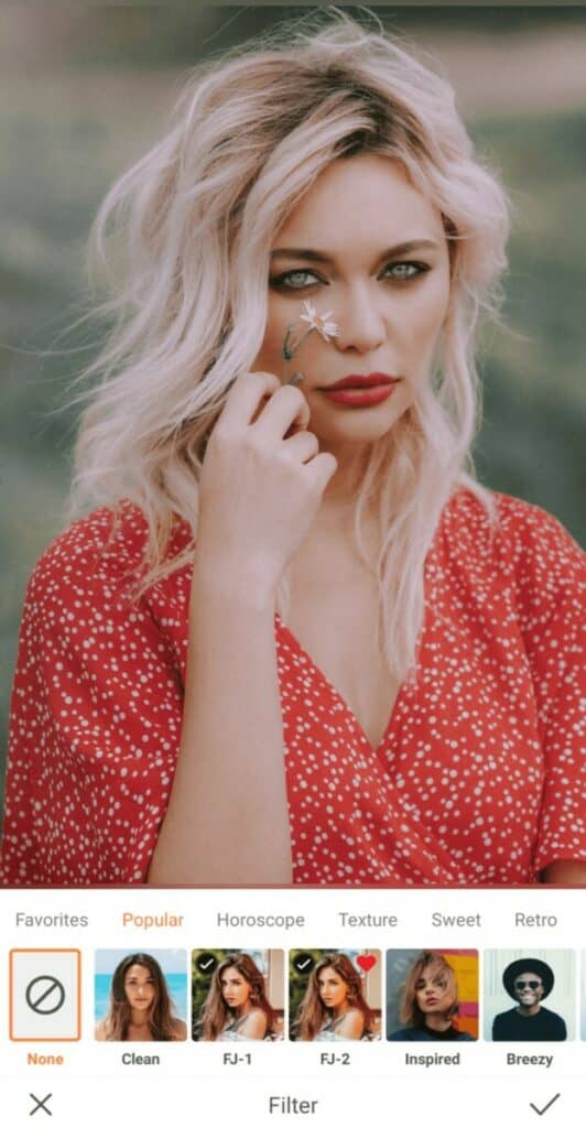 woman with blonde hair holding a flower