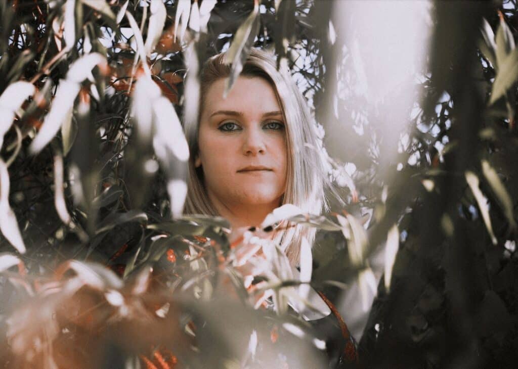 woman surrounded by green leaves