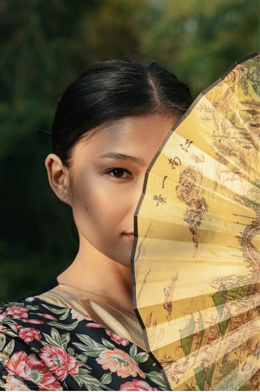 girl hiding behind a fan