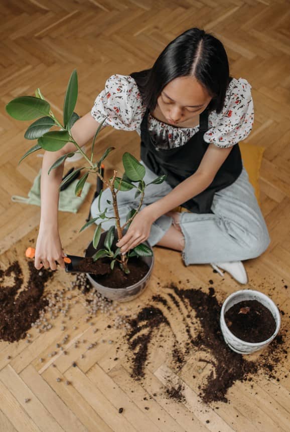 woman sitting on the floor potting plants