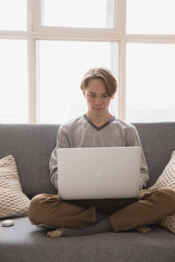 Homem sentado mexendo no laptop