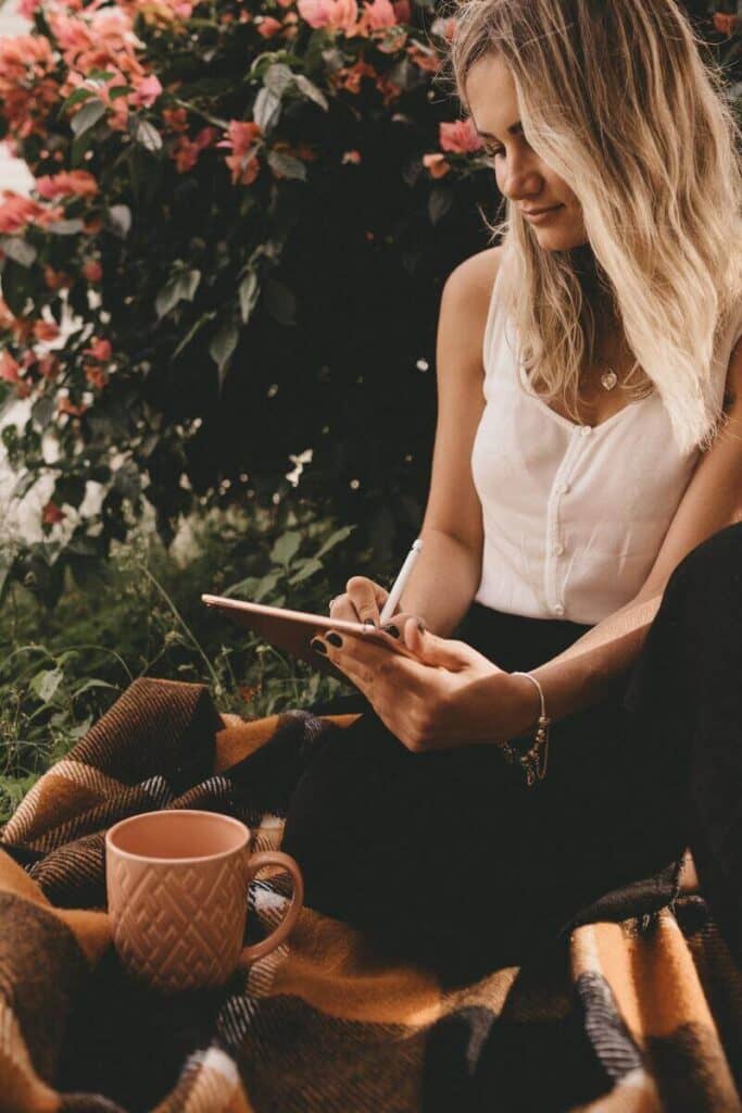 mulher escrevendo com uma paisagem de natureza ao fundo